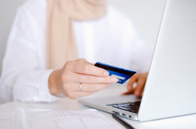 person holding a credit card to make an online payment